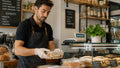 Un addetto confeziona alimenti dietro il banco di un piccolo bar